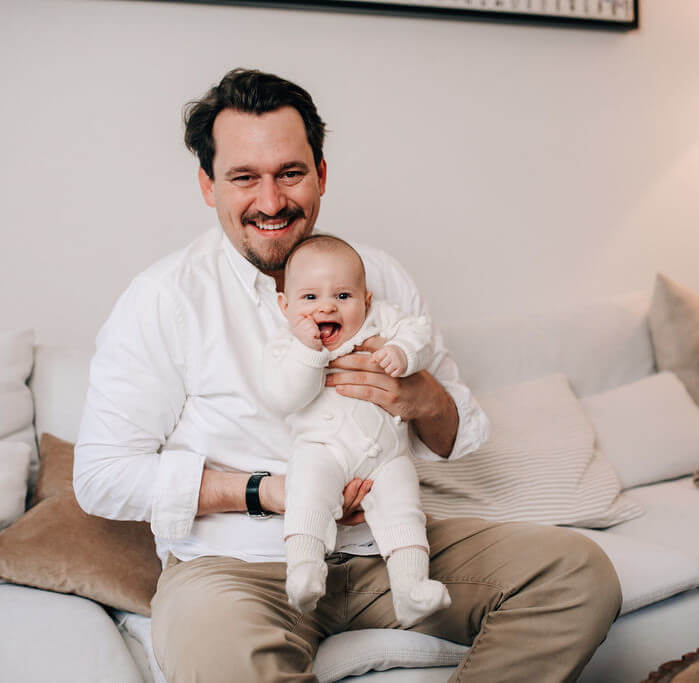 Vater hält seine Tochter im Wohnzimmer hoch