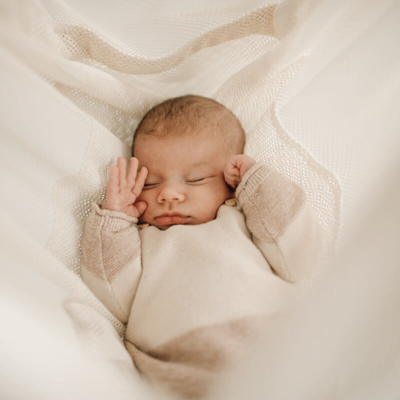 Baby m&uuml;de in wei&szlig;er Federwiege MATTI liegend