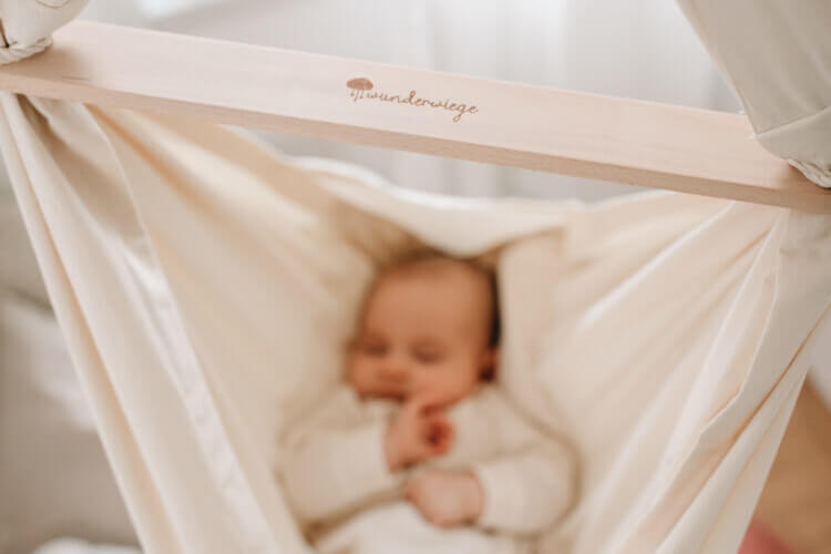 Schlafendes Baby liegend in Babyh&auml;ngematte WOLLI mit Wunderwiege Logo