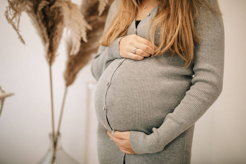 Schwangere Frau hält ihren Bauch
